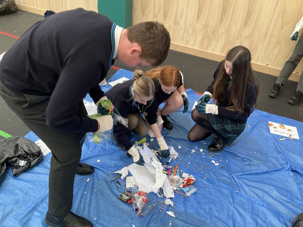 A group of students sorting through a pile of rubbish.