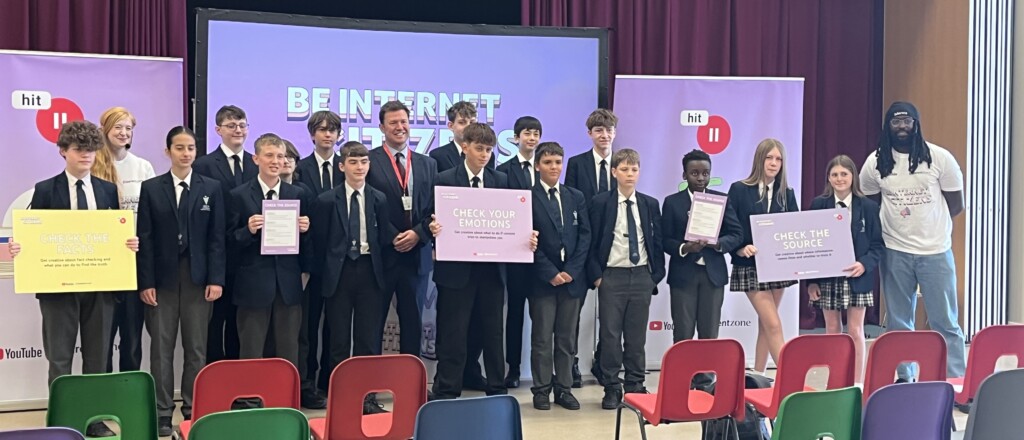 Students stood for a photo, holding signs that say 'Check your emotions'.