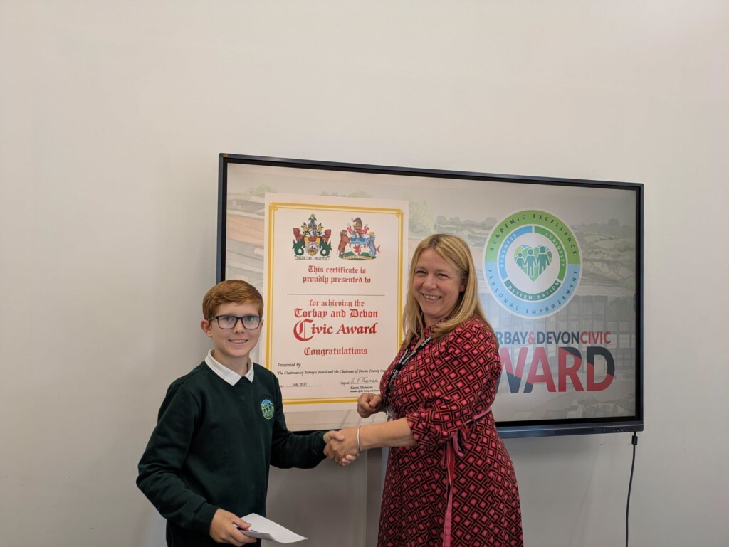 An Exwick Heights pupil shaking hands while getting his award