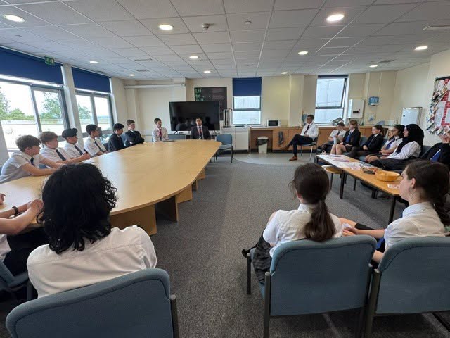 Students sat around tables listening 