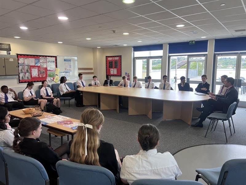 Students sat around tables talking with Mr Reed