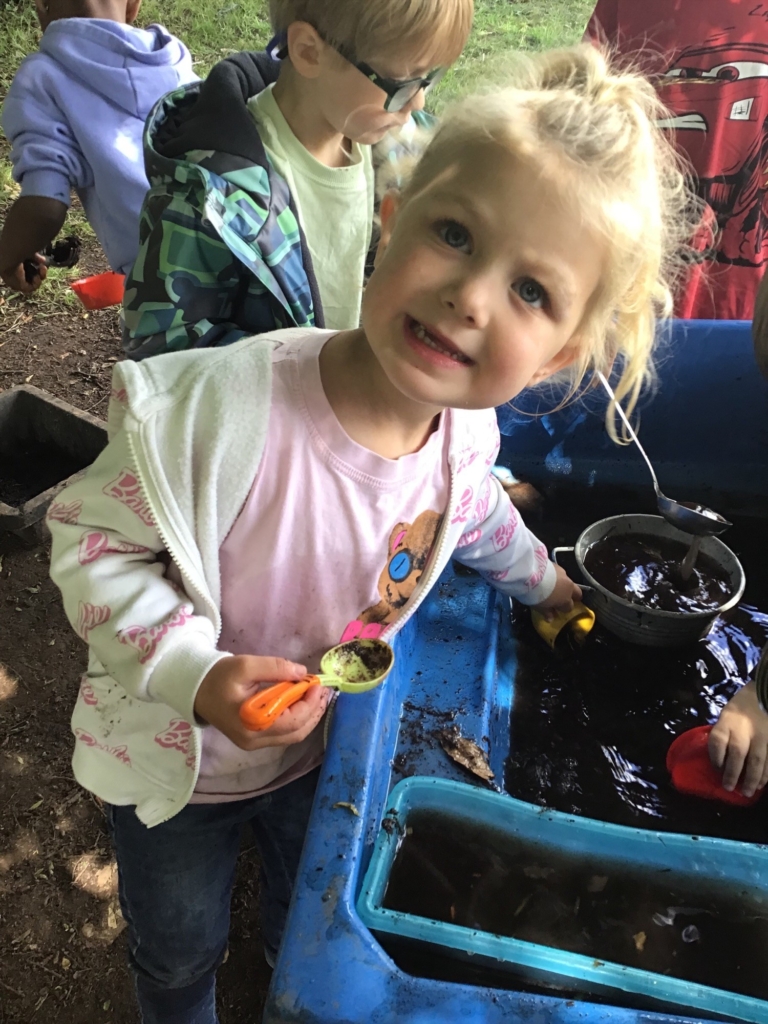 A pupil helping fill pots with soil and water