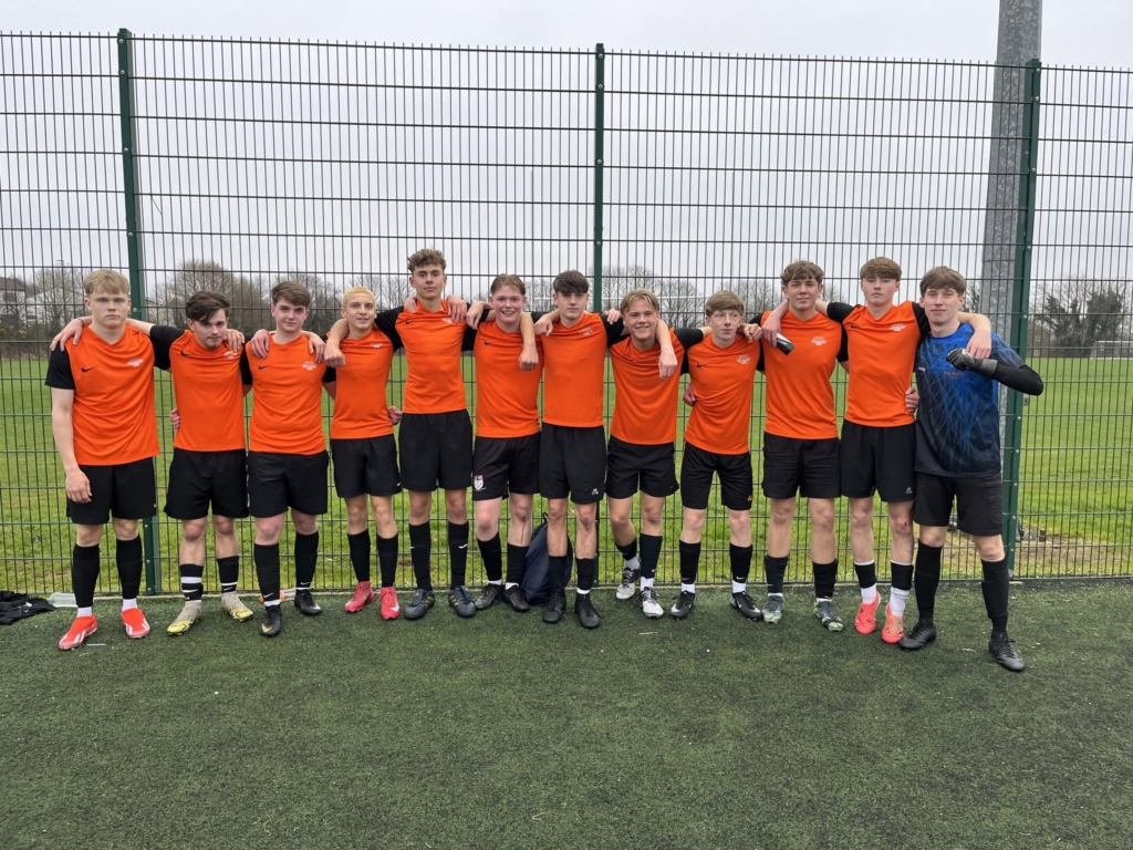 Group of footballers with arms round each other smiling