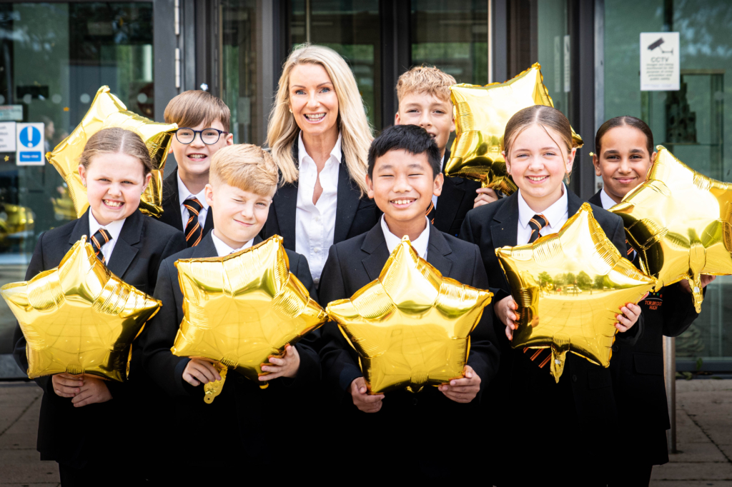Headteacher Tracy with students holding star balloons