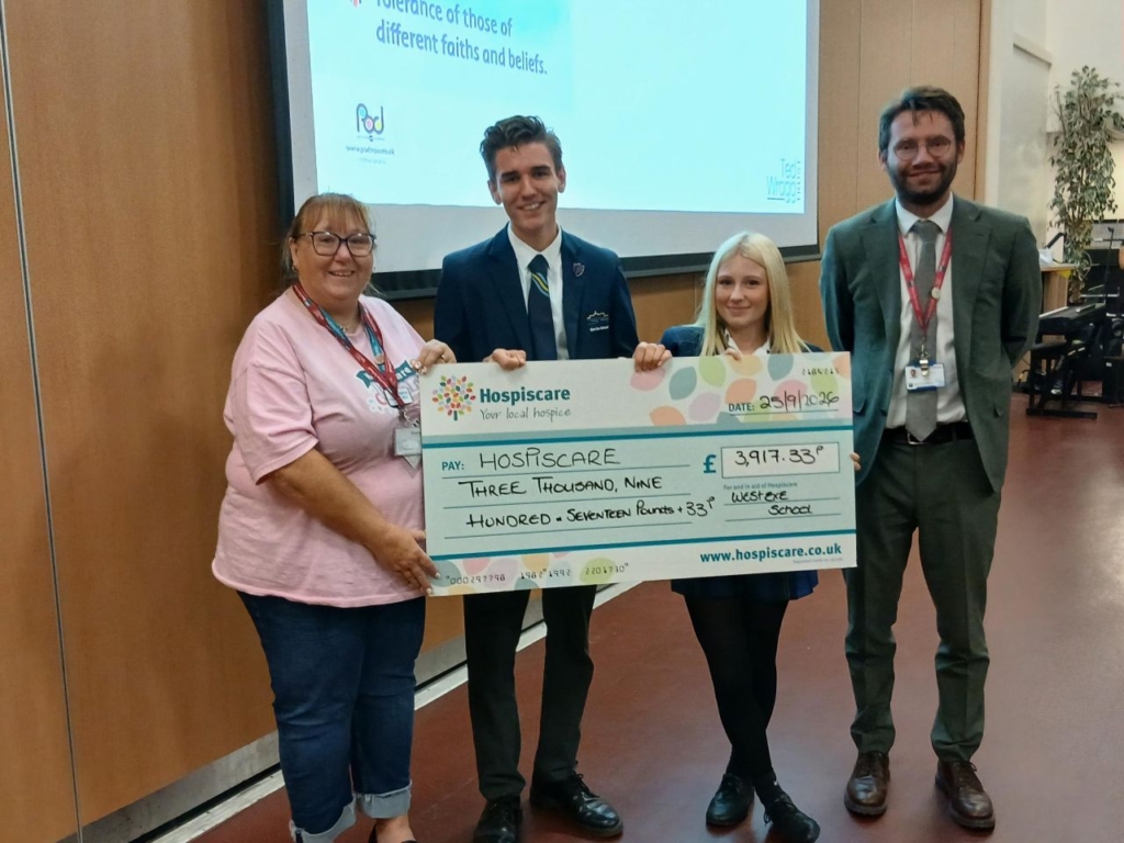 West Exe head students with headteacher Jamie Engineer and a Hospiscare representative holding a big cheque.