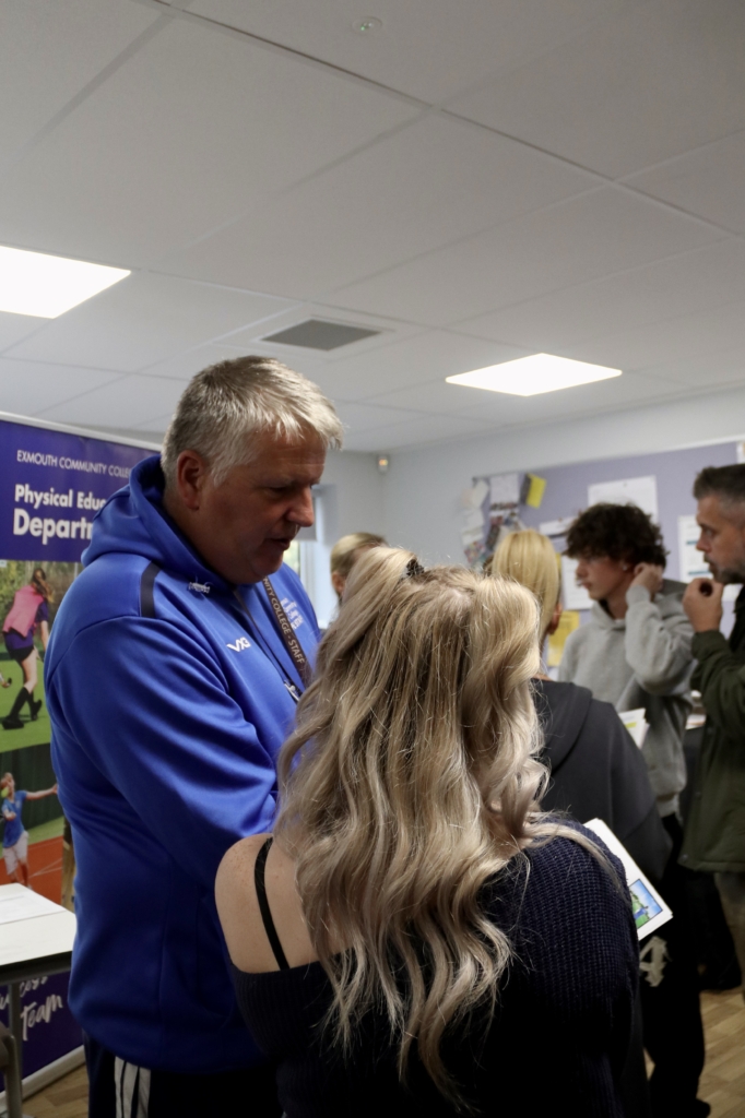 A PE teacher talking with prospective students