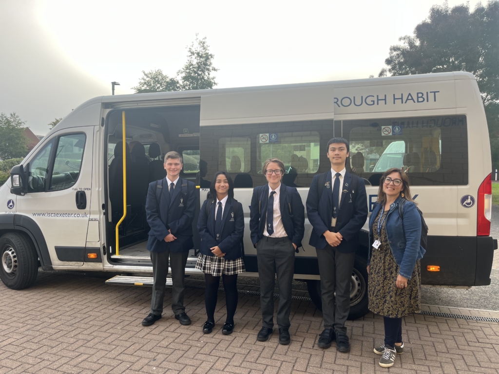 Isca students and a member of staff in front of their school mini bus
